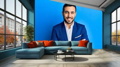 Young hispanic businessman wearing business jacket happy face smiling with crossed arms looking at the camera. positive person. Wall mural