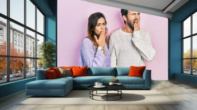 Young hispanic couple wearing casual clothes bored yawning tired covering mouth with hand. restless and sleepiness. Wall mural