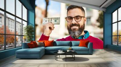 Young hispanic executive man smiling happy holding 20 dollars banknote at the city. Wall mural