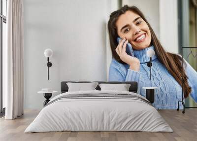 Young hispanic girl  smiling happy talking on the smartphone at the city Wall mural