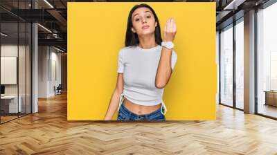 Young hispanic girl wearing casual white t shirt doing italian gesture with hand and fingers confident expression Wall mural