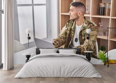 Young hispanic man army soldier using laptop sitting on table at home Wall mural