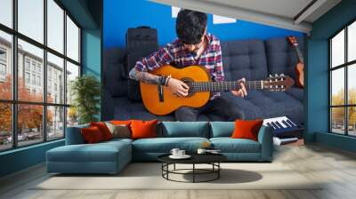 Young hispanic man artist playing classical guitar at music studio Wall mural