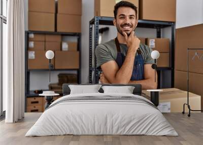 Young hispanic man business worker smiling confident standing at storehouse Wall mural