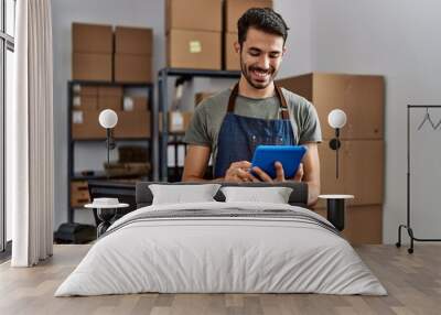 Young hispanic man business worker using touchpad at storehouse Wall mural