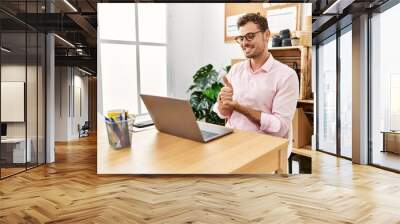 Young hispanic man having video call communicating with deaf sign language at office Wall mural