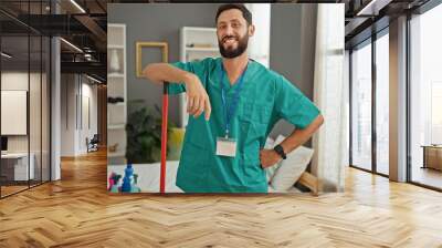 Young hispanic man professional cleaner smiling confident standing at bedroom Wall mural