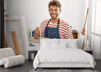 Young hispanic man smiling confident drawing at art studio Wall mural