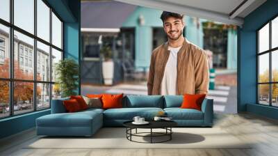 Young hispanic man smiling confident standing at street Wall mural