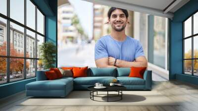 Young hispanic man smiling confident standing with arms crossed gesture at street Wall mural