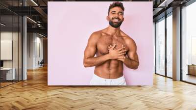 Young hispanic man standing shirtless smiling with hands on chest with closed eyes and grateful gesture on face. health concept. Wall mural