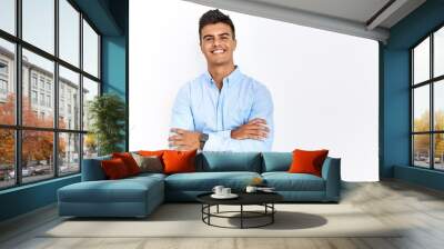 Young hispanic man wearing business shirt standing over isolated background happy face smiling with crossed arms looking at the camera. positive person. Wall mural