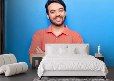 Young hispanic man wearing casual clothes happy face smiling with crossed arms looking at the camera. positive person. Wall mural