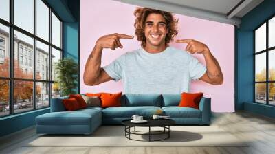 Young hispanic man wearing casual clothes smiling cheerful showing and pointing with fingers teeth and mouth. dental health concept. Wall mural