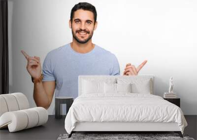 Young hispanic man wearing casual clothes smiling confident pointing with fingers to different directions. copy space for advertisement Wall mural