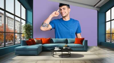 Young hispanic man wearing casual t shirt smiling pointing to head with one finger, great idea or thought, good memory Wall mural