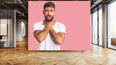 Young hispanic man wearing casual white tshirt shouting and suffocate because painful strangle. health problem. asphyxiate and suicide concept. Wall mural