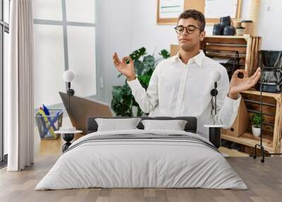 Young hispanic man working with laptop at business office Wall mural