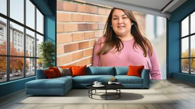 Young hispanic plus size woman smiling happy standing at the city. Wall mural