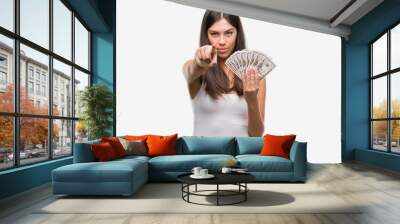 Young hispanic woman holding dollars pointing with finger to the camera and to you, hand sign, positive and confident gesture from the front Wall mural