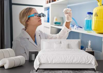 Young hispanic woman scientist looking diamond with zoom glasses at laboratory Wall mural