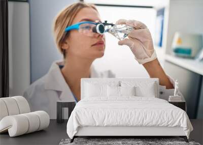 Young hispanic woman scientist looking diamond with zoom glasses at laboratory Wall mural