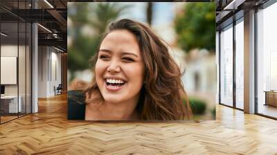 Young hispanic woman smiling happy standing at the city. Wall mural