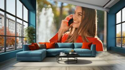 Young hispanic woman smiling happy talking on the smartphone at the city. Wall mural