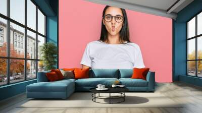 Young hispanic woman wearing casual white t shirt making fish face with lips, crazy and comical gesture. funny expression. Wall mural