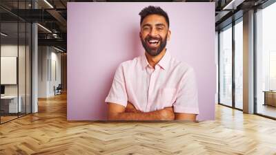 Young indian man wearing casual shirt standing over isolated pink background happy face smiling with crossed arms looking at the camera. Positive person. Wall mural