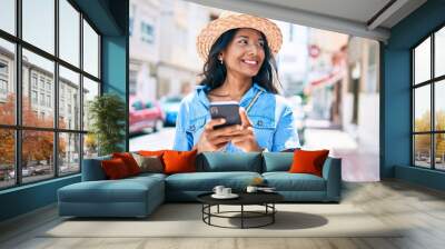 Young indian woman smiling happy using smartphone at the city Wall mural