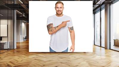 Young irish man wearing casual clothes cheerful with a smile of face pointing with hand and finger up to the side with happy and natural expression on face Wall mural