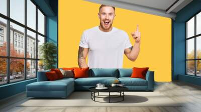 Young irish man wearing casual clothes pointing finger up with successful idea. exited and happy. number one. Wall mural