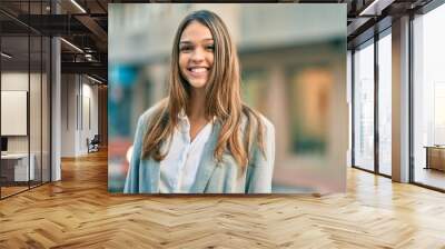 Young latin businesswoman smiling happy standing at the city. Wall mural