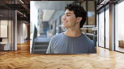 Young latin man smiling confident looking to the side at street Wall mural