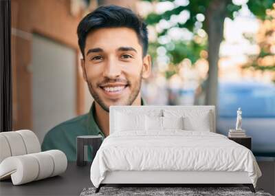 Young latin man smiling happy walking at the city. Wall mural