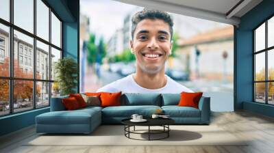 Young latin man smiling happy walking at the city. Wall mural