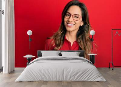 Young latin woman wearing casual clothes and glasses with a happy and cool smile on face. lucky person. Wall mural