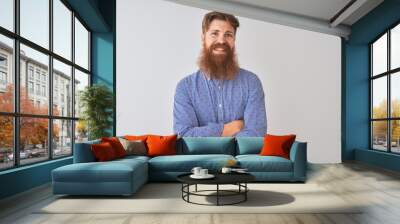 Young redhead irish man wearing casual shirt standing over isolated white background happy face smiling with crossed arms looking at the camera. Positive person. Wall mural