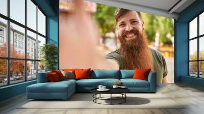 Young redhead man smiling confident make selfie by the camera at street Wall mural