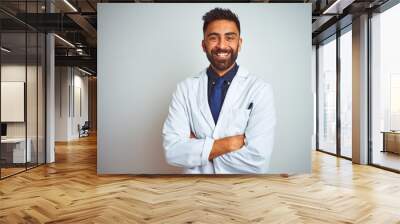 Young smiling doctor standing against white background Wall mural