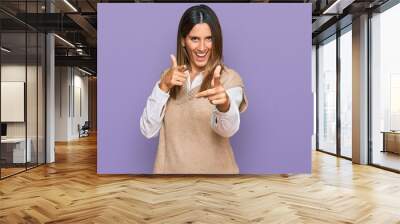 Young woman wearing casual clothes pointing fingers to camera with happy and funny face. good energy and vibes. Wall mural