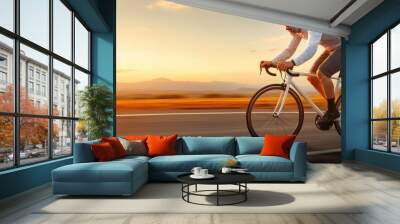 A cyclist riding fast on a paved road at sunset, with a scenic mountainous landscape in the distance. Wall mural