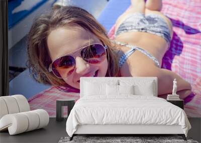 Portrait of a young girl lying in the sun Wall mural