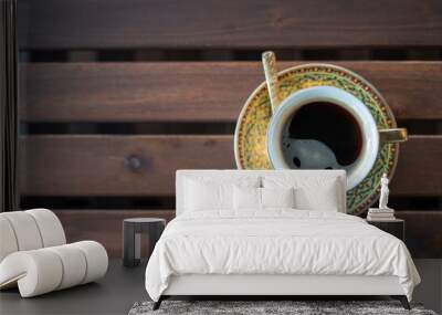 A beautiful cup of coffee with spoon and saucer on a pattern table in the morning. top view. and vintage Wall mural