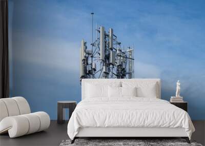 Telecommunication tower of 4G and 5G cellular. Macro Base Station. 5G radio network telecommunication equipment with radio modules and smart antennas mounted on a metal against cloulds sky background. Wall mural