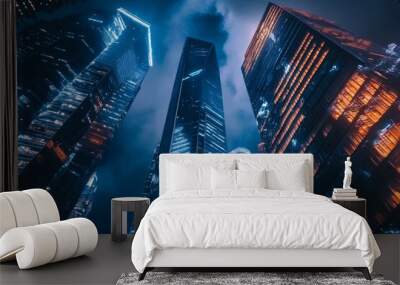 A low angle view of tall skyscrapers at night with illuminated windows. Wall mural