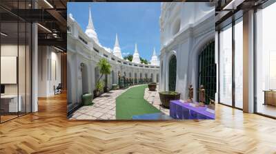 Thailand, August 11, 2024, Wat Prayurawongsawas Worawihan, Beautiful white pagodas surround a tranquil walkway in a serene temple courtyard on a sunny day Wall mural