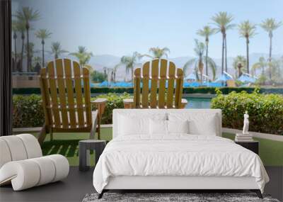 Wooden two chairs by the pool with green artificial grass. Wall mural