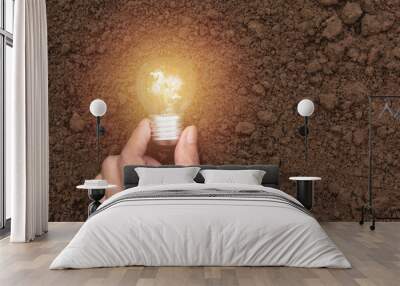 Hand with light bulbs with glowing on ground. Idea, creativity and saving energy with light bulbs concept. Wall mural